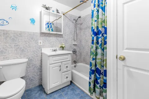 a bathroom with a sink a toilet and a shower curtain