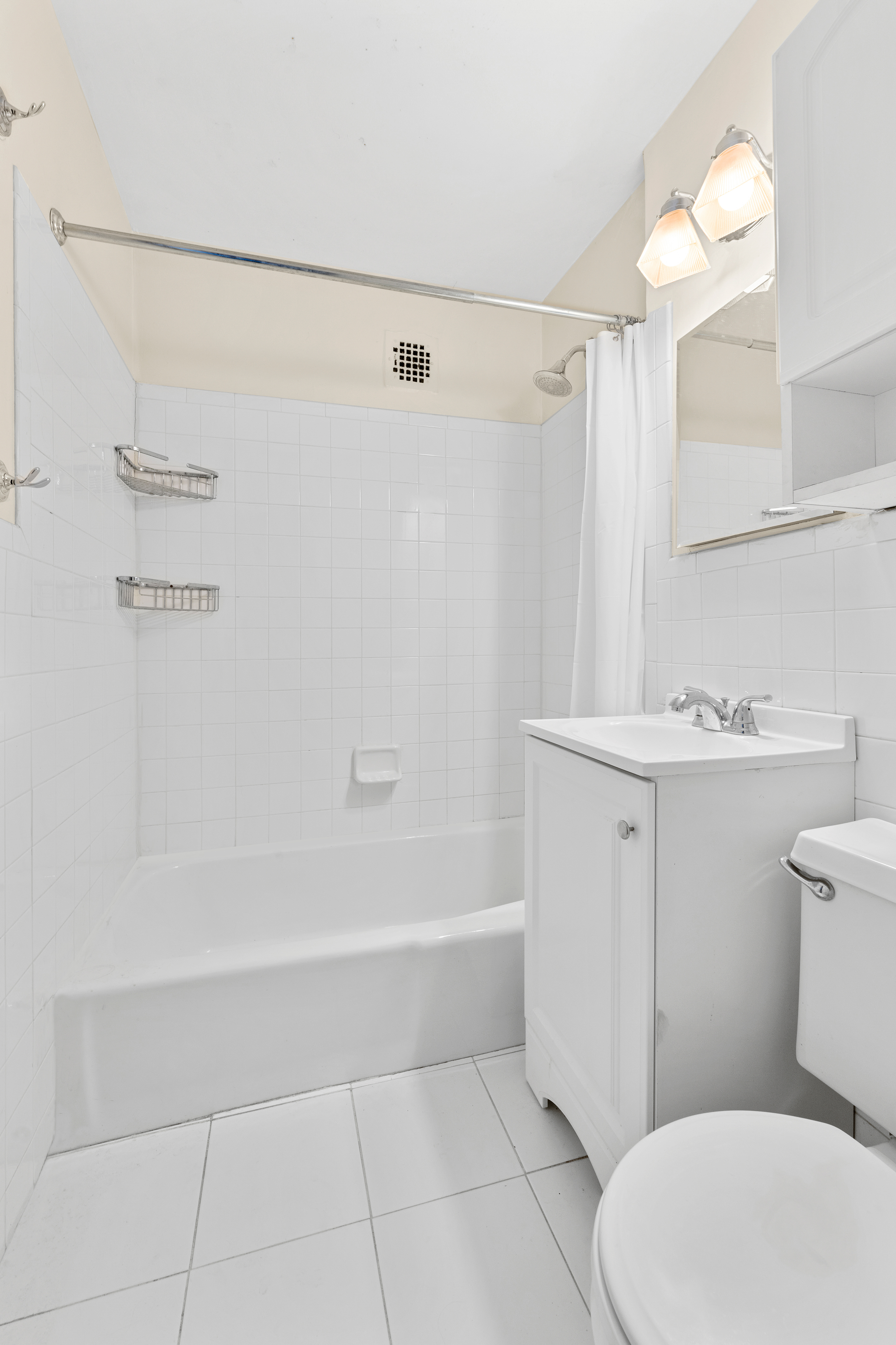 160 East 91st Street, Unit 4A Manhattan, NY 10128 - Photo 7 of 8 a bathroom with a sink a toilet and shower