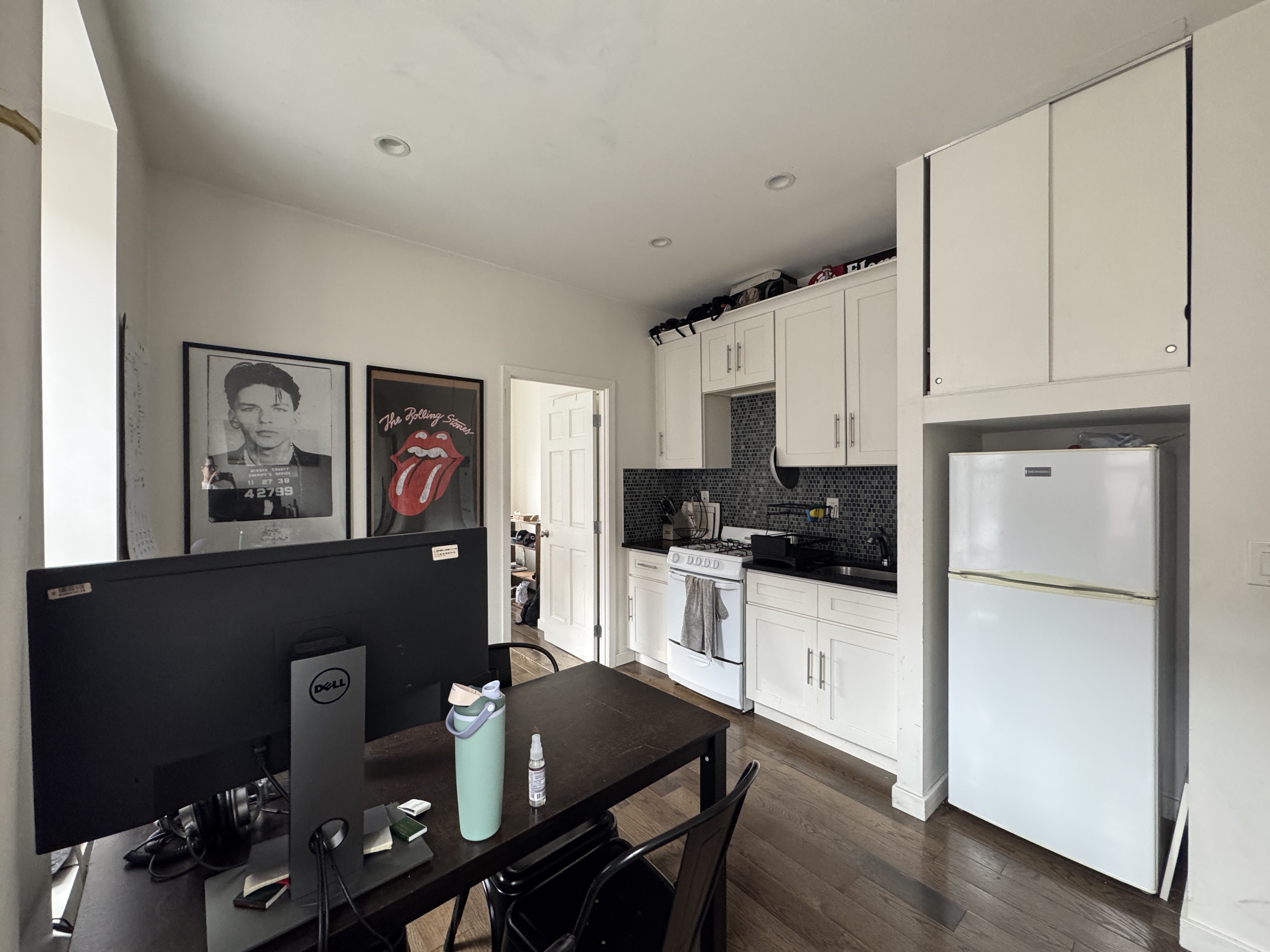 108 Stanton Street, Unit 1A Manhattan, NY 10002 - Photo 5 of 11 a kitchen with stainless steel appliances granite countertop a refrigerator a stove a sink dishwasher and white cabinets with wooden floor