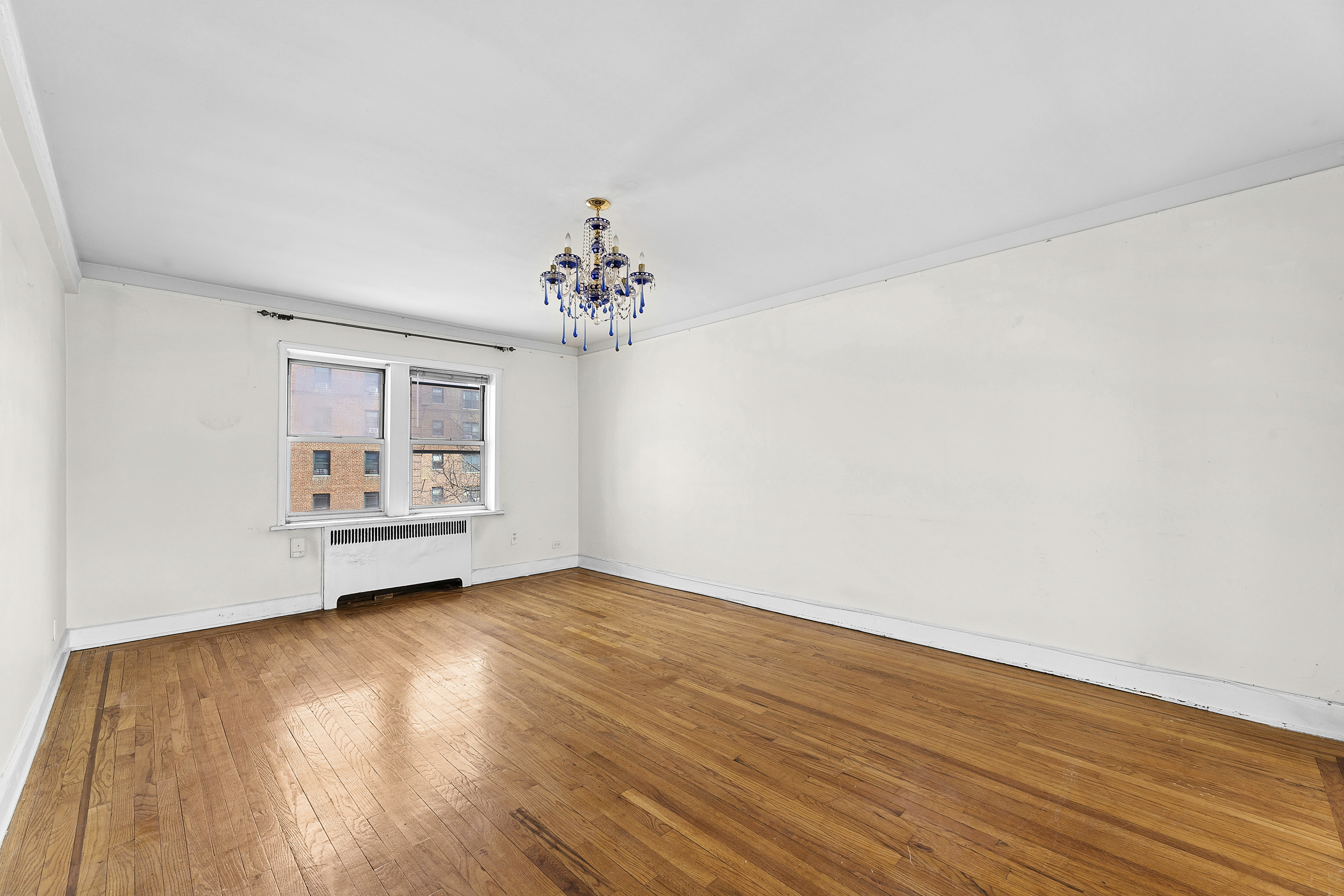 5444 Arlington Avenue, Unit G51 Bronx, NY 10471 - Photo 3 of 16 a view of an empty room with wooden floor and a window