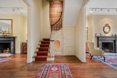 a view of an entryway with wooden floor a fireplace and a chandelier