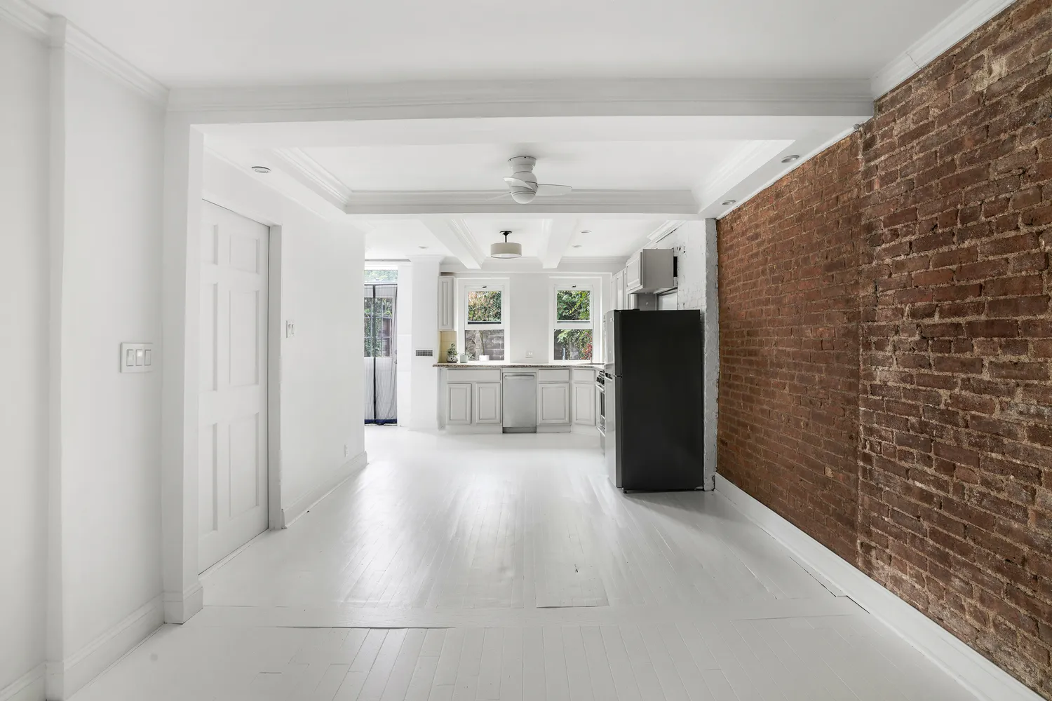 a view of a hallway with wooden floor and windows