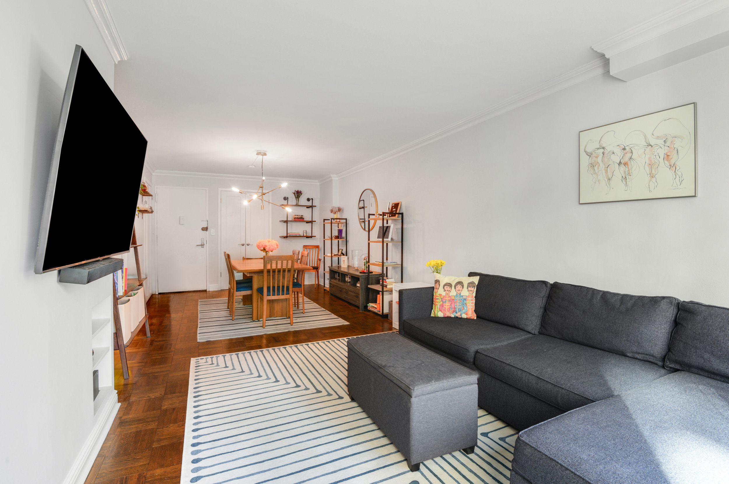 345 East 73rd Street, Unit 7J Manhattan, NY 10021 - Photo 4 of 13 a living room with furniture and a flat screen tv