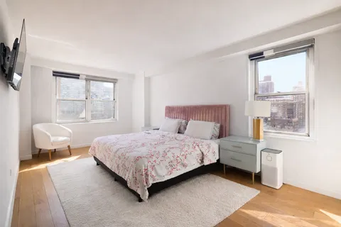 a bedroom with a bed chair and window