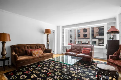 a living room with furniture and a floor to ceiling window