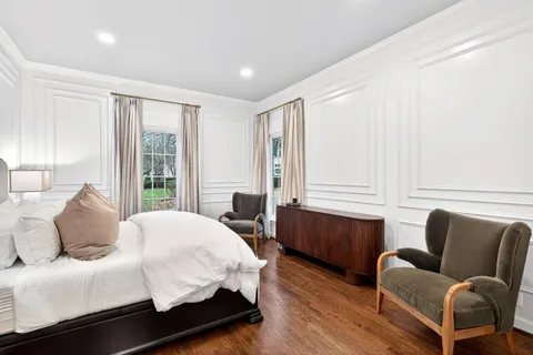 a bedroom with a bed couch and windows