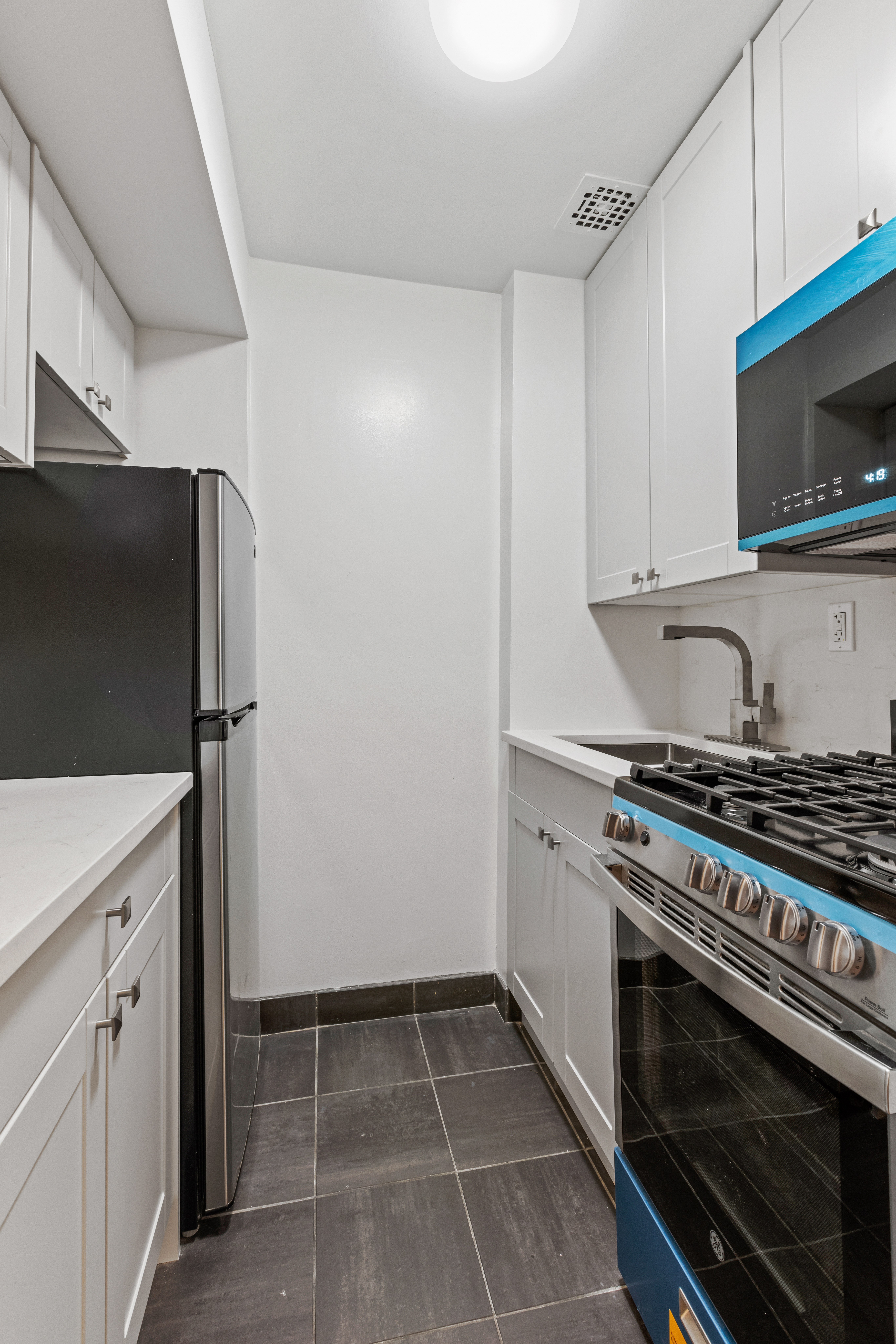 310 East 23rd Street, Unit 5B Manhattan, NY 10010 - Photo 7 of 11 a kitchen with a stove and a microwave