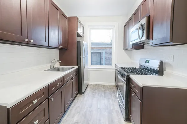 a kitchen with stainless steel appliances granite countertop a sink stove and cabinets