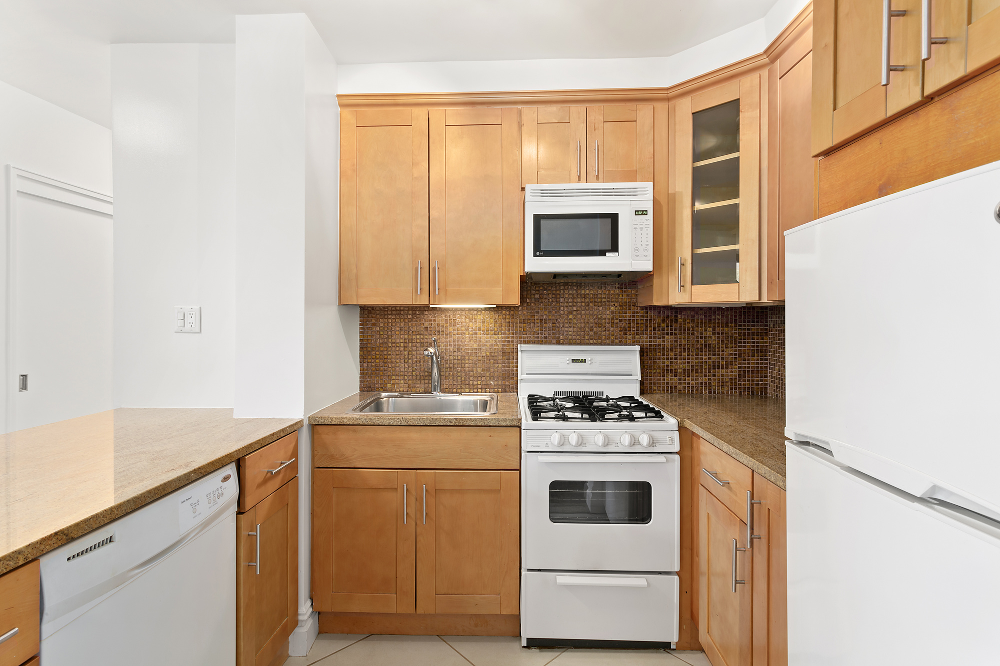 165 Christopher Street, Unit LCC Manhattan, NY 10014 - Photo 3 of 5 a kitchen with stainless steel appliances white cabinets and a stove