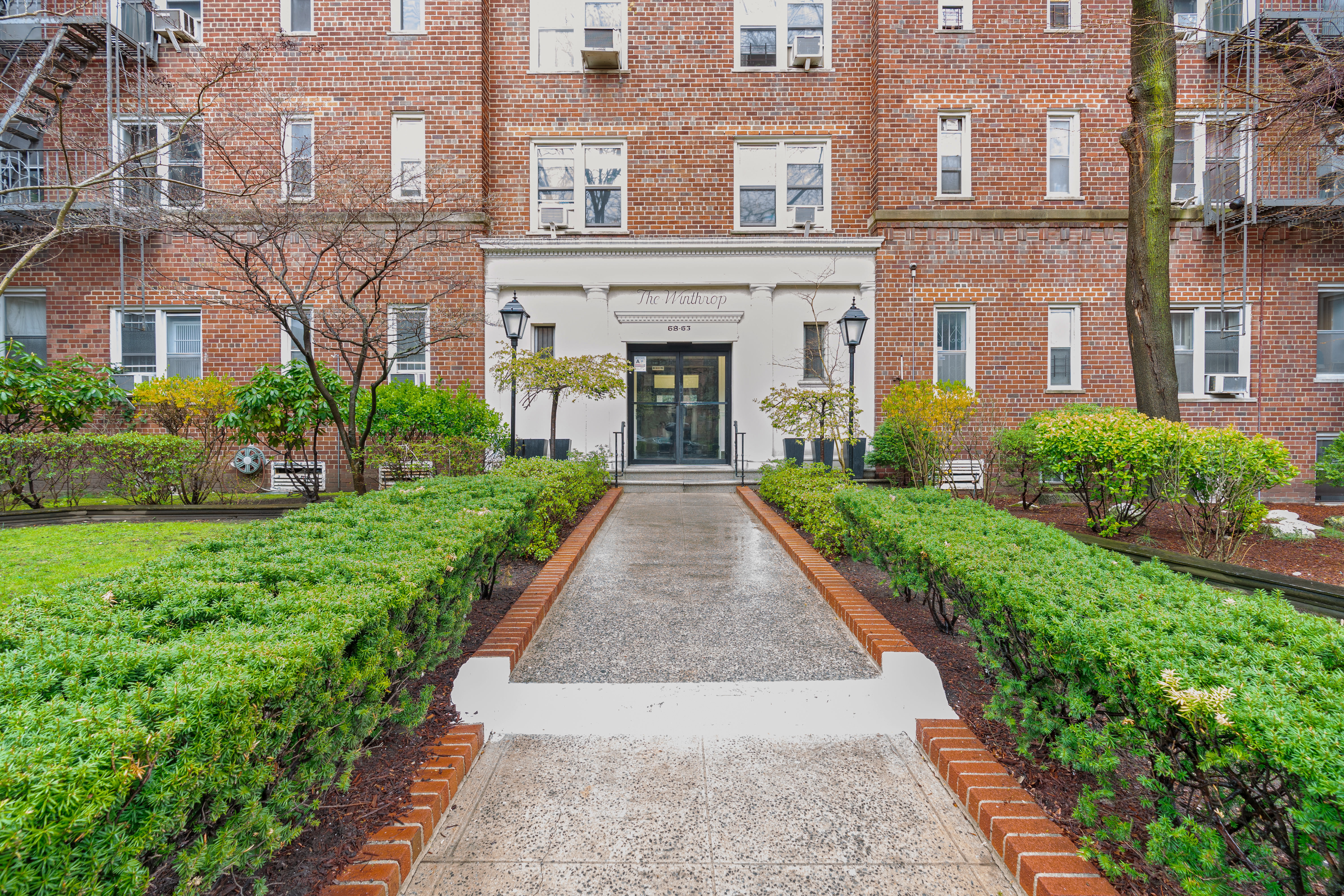 68-63 108th Street, Unit 1B Queens, NY 11375 - Photo 11 of 13 a front view of a building with garden
