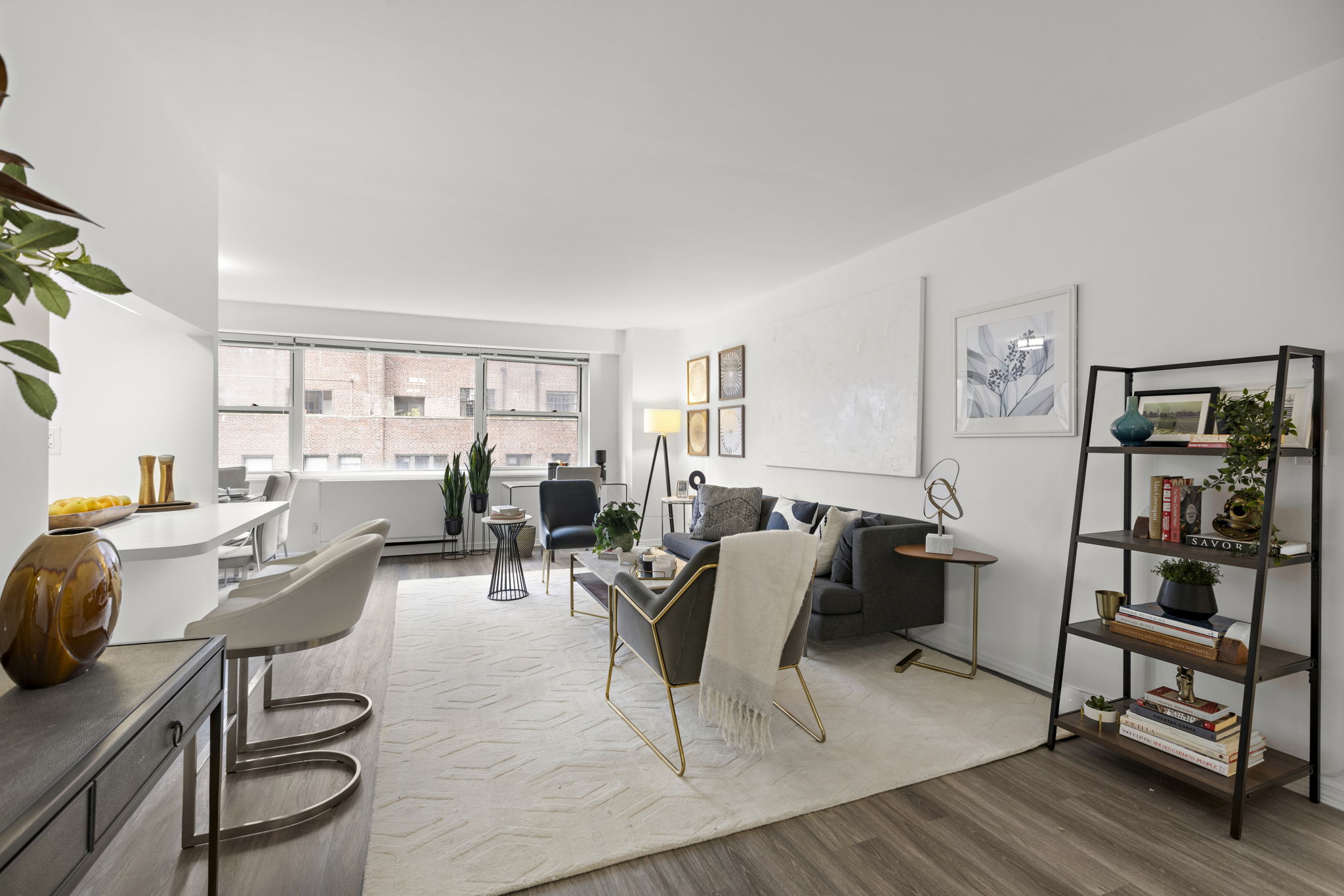 a living room with furniture a wooden floor and next to a window