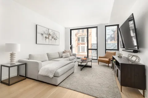 a living room with furniture and large windows