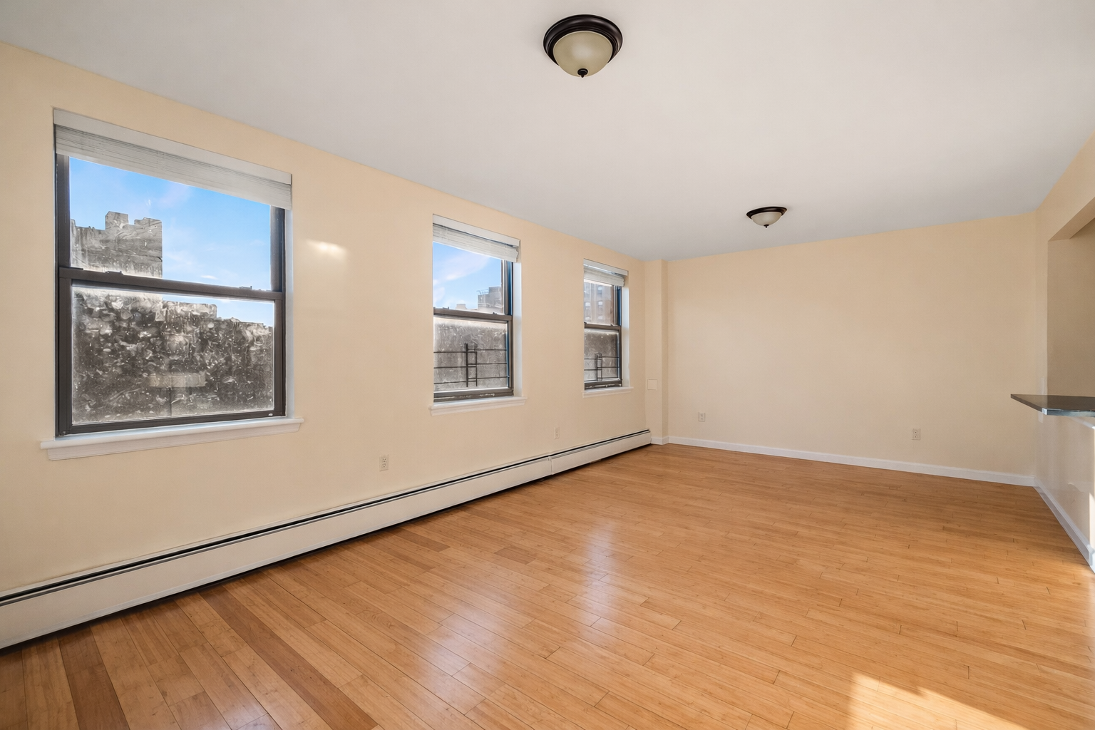 415 East 160th Street, Unit 3 Bronx, NY 10451 - Photo 2 of 10 a view of an empty room with wooden floor and a window