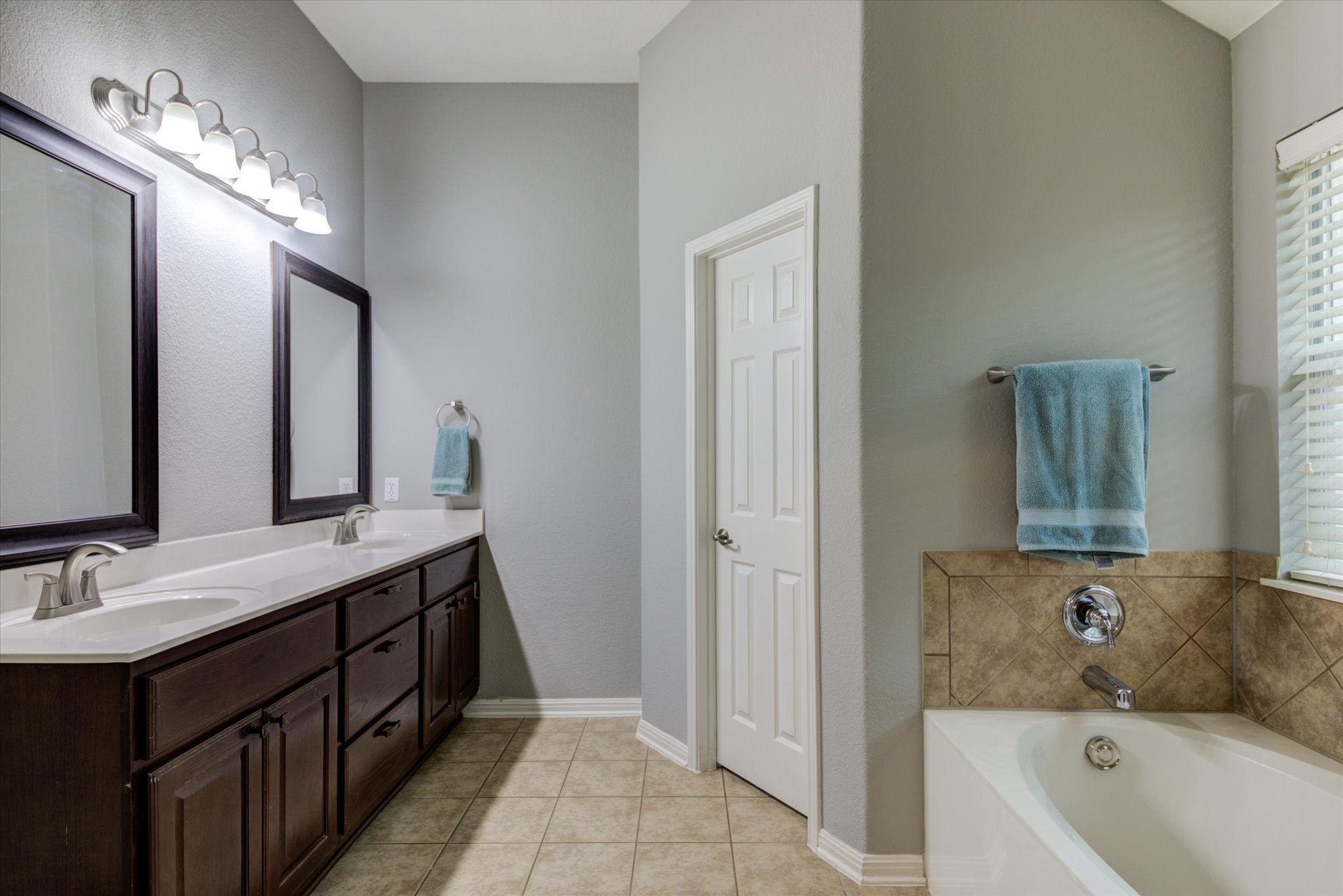 5412 Batak Lane Austin, TX 78749 - Photo 28 of 40 a bathroom with a tub a double vanity sink and mirror