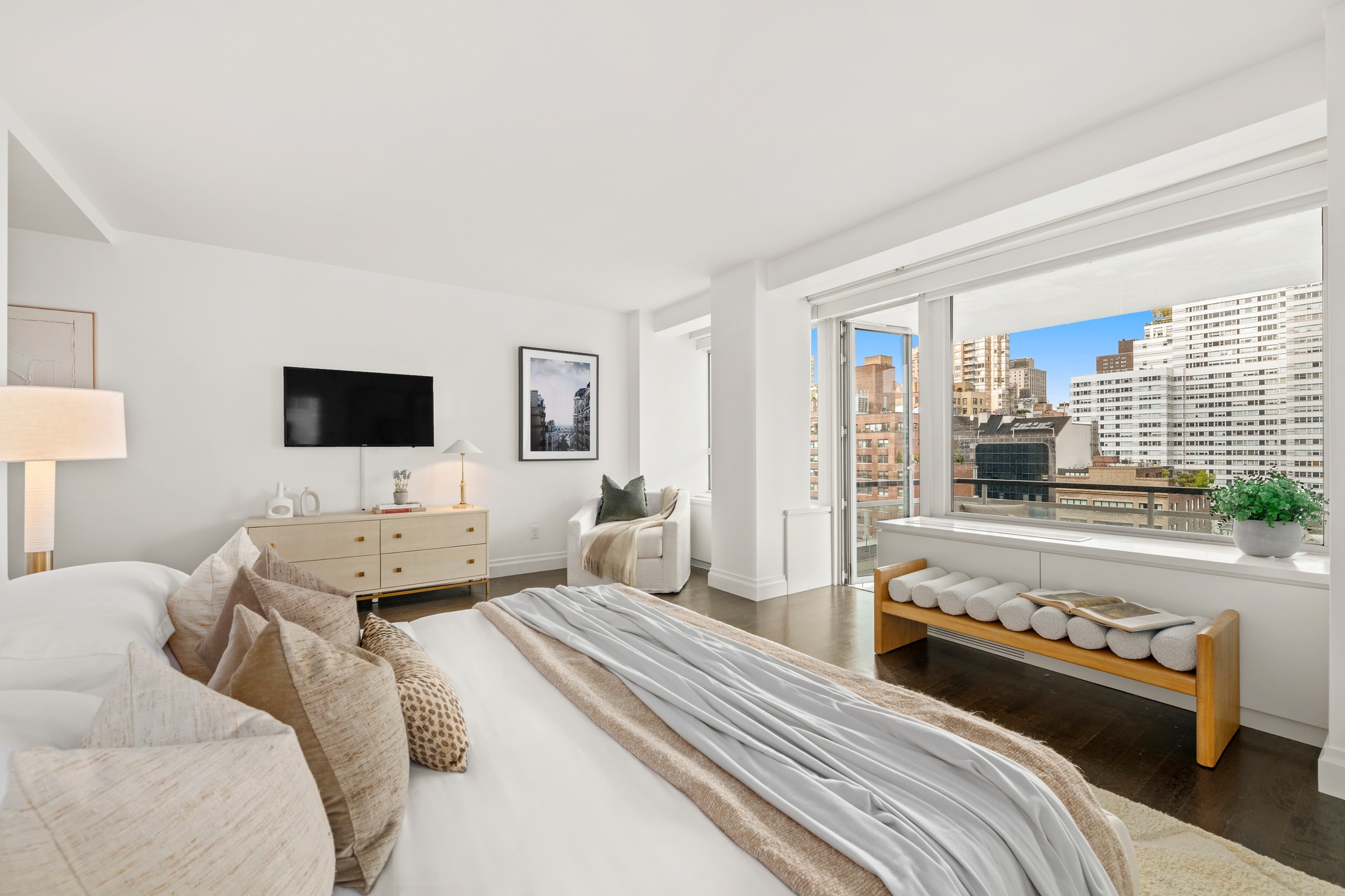 200 East 66th Street, Unit D1205 Manhattan, NY 10065 - Photo 7 of 33 a bedroom with a bed and a flat screen tv