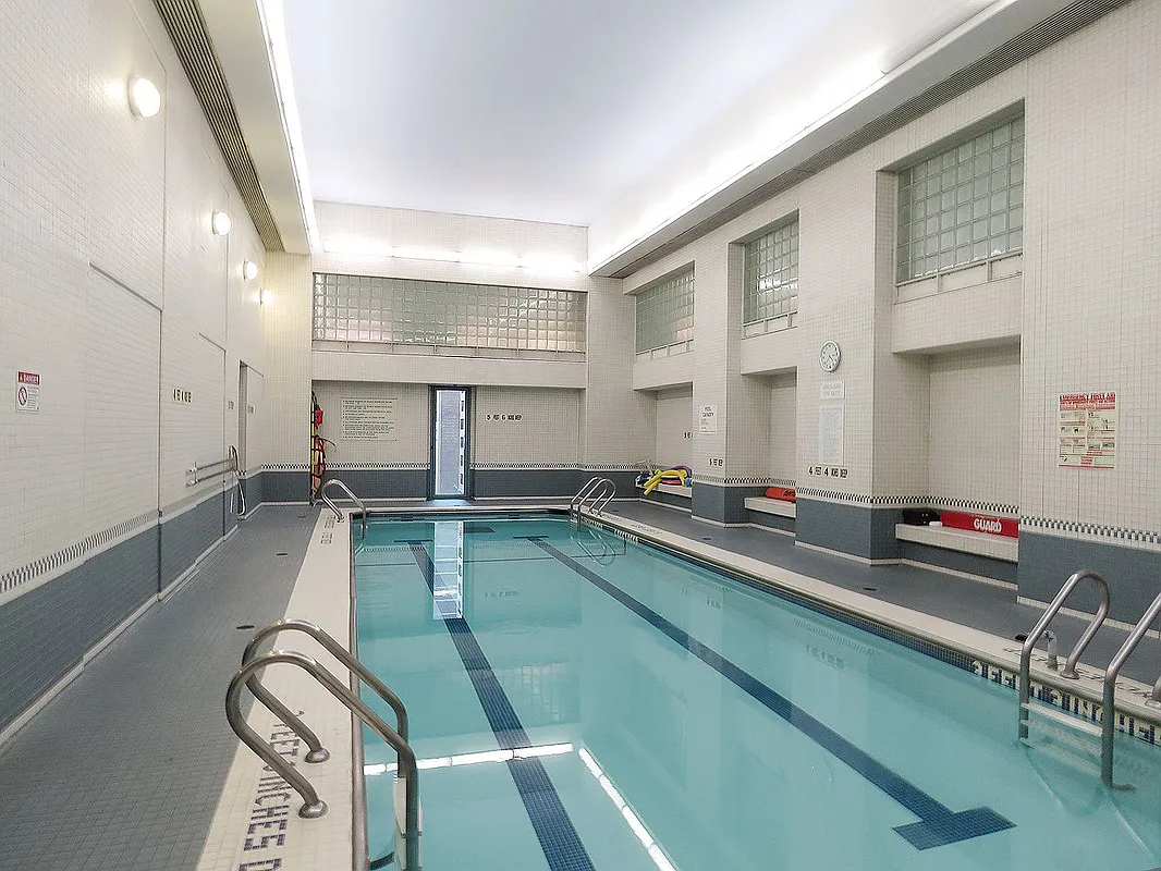 301 West 57th Street, Unit 22E Manhattan, NY 10019 - Photo 11 of 13 a room with lots of wooden furniture and a large window