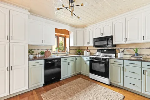 a kitchen with cabinets stainless steel appliances and a window
