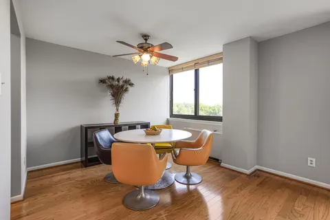 a dining room with furniture a chandelier and wooden floor