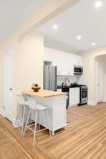 a kitchen with stainless steel appliances kitchen island granite countertop a stove a sink and a refrigerator