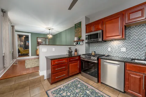 a kitchen with stainless steel appliances granite countertop a stove a sink and a microwave
