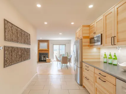 a lobby with stainless steel appliances kitchen island granite countertop a refrigerator and cabinets