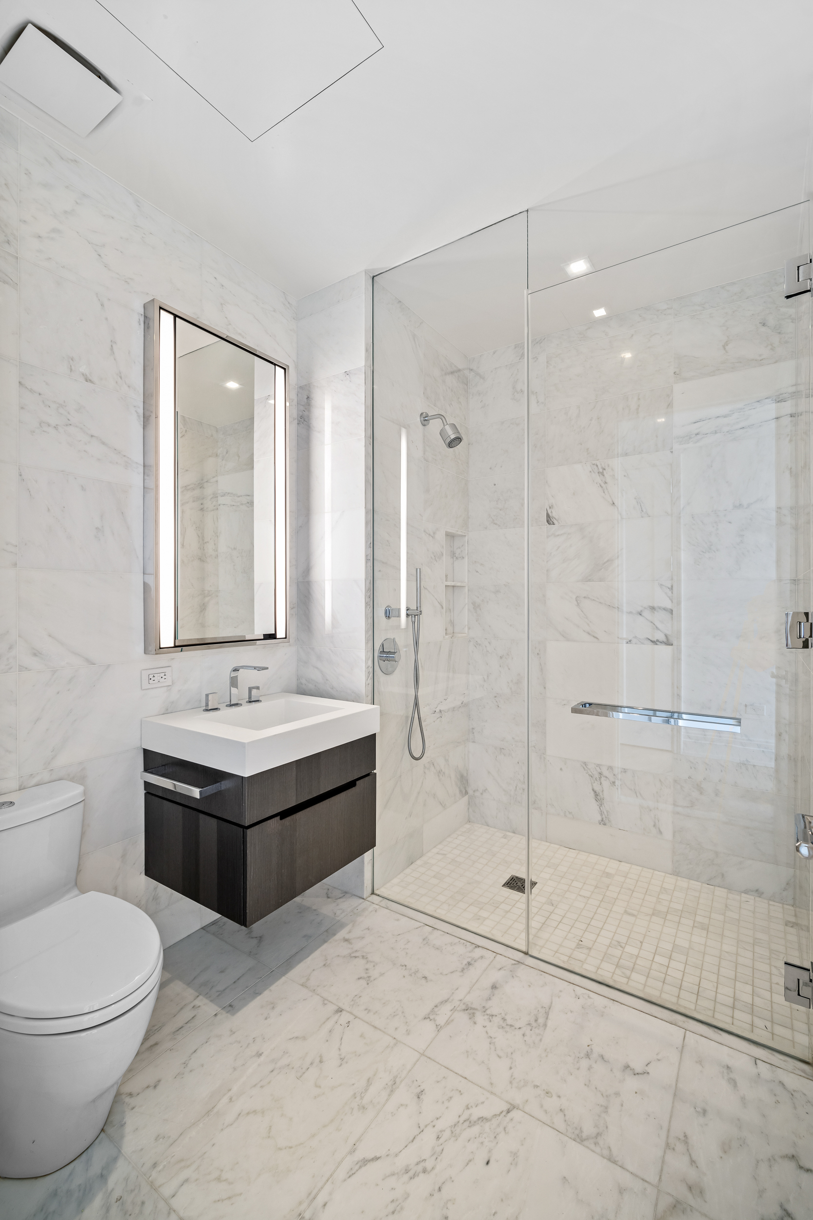 108 Leonard Street, Unit 12F Manhattan, NY 10013 - Photo 10 of 15 a bathroom with a granite countertop sink a toilet and shower