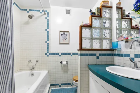 a bathroom with a granite countertop sink and a bathtub