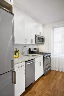 a kitchen with stainless steel appliances granite countertop a stove a sink and a refrigerator