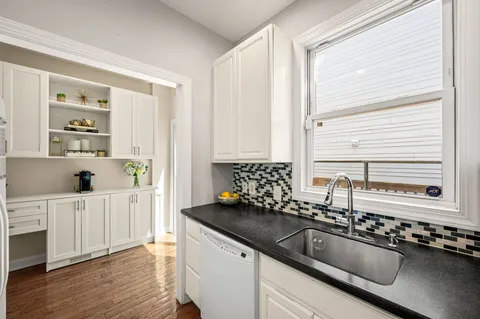 a kitchen with stainless steel appliances a sink a stove and a window