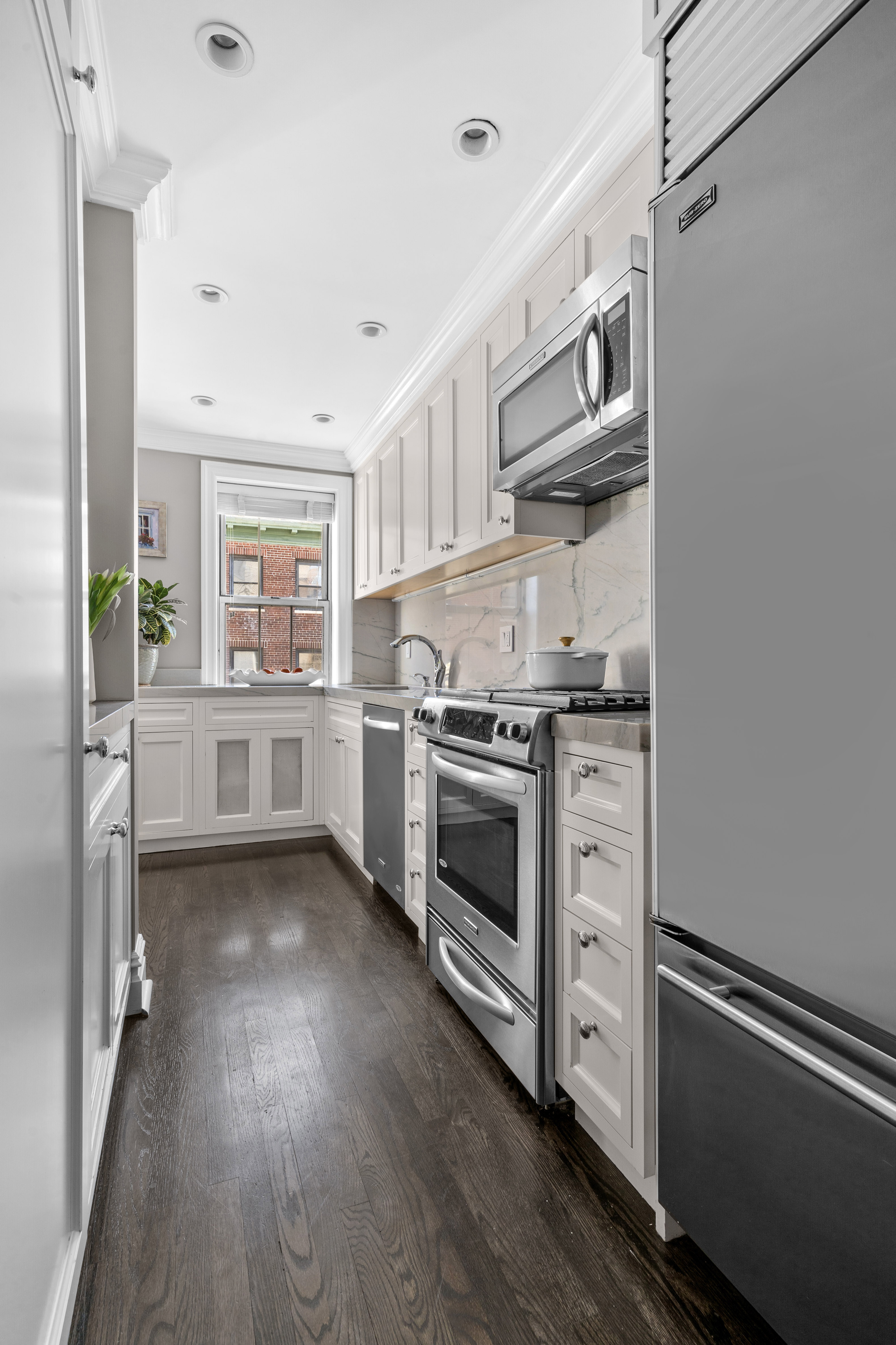 75 Bank Street, Unit 3K Manhattan, NY 10014 - Photo 3 of 11 a kitchen with stainless steel appliances a stove and a refrigerator