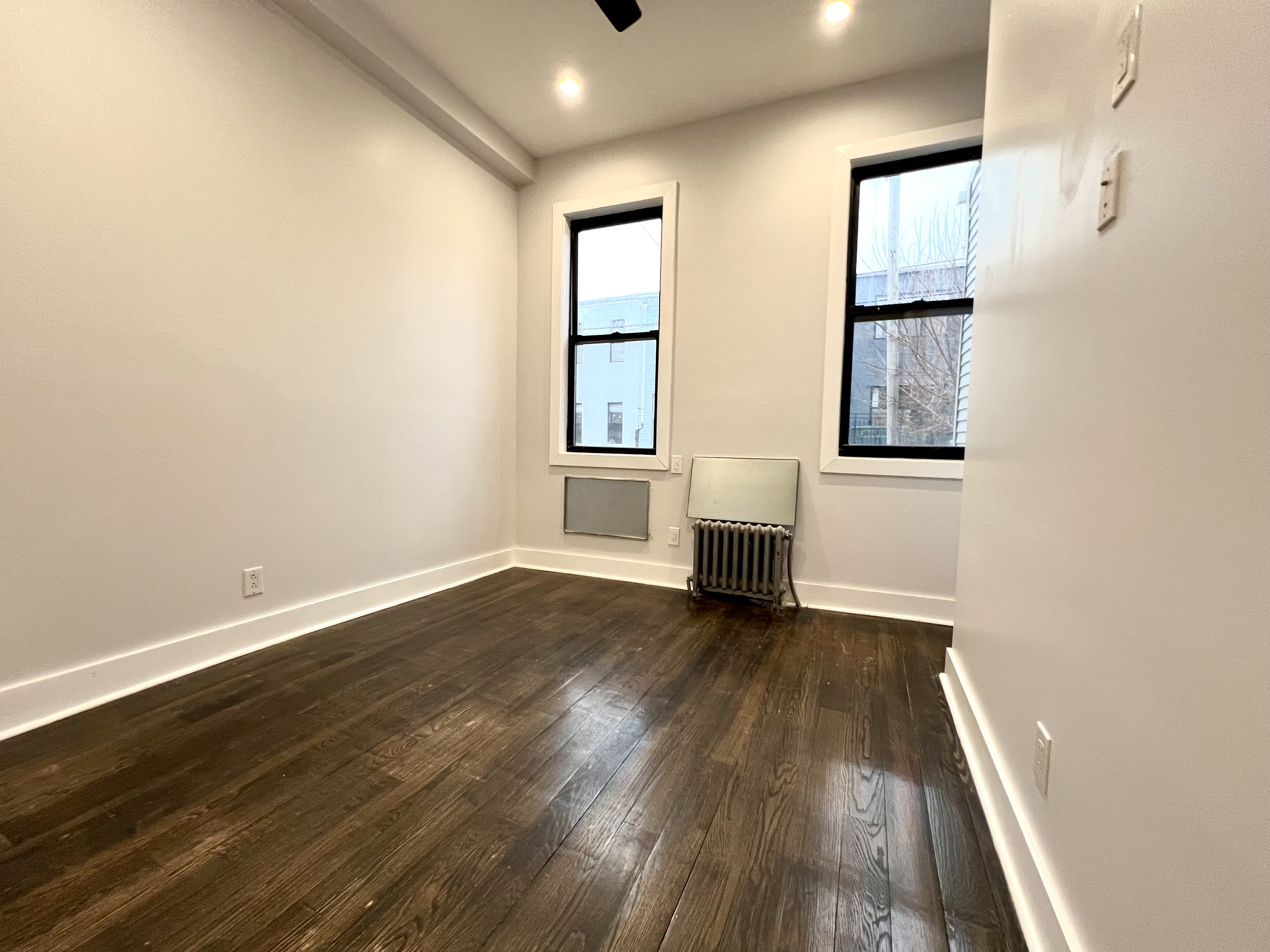 20 Suydam Street, Unit 1 Brooklyn, NY 11221 - Photo 9 of 10 an empty room with wooden floor and windows
