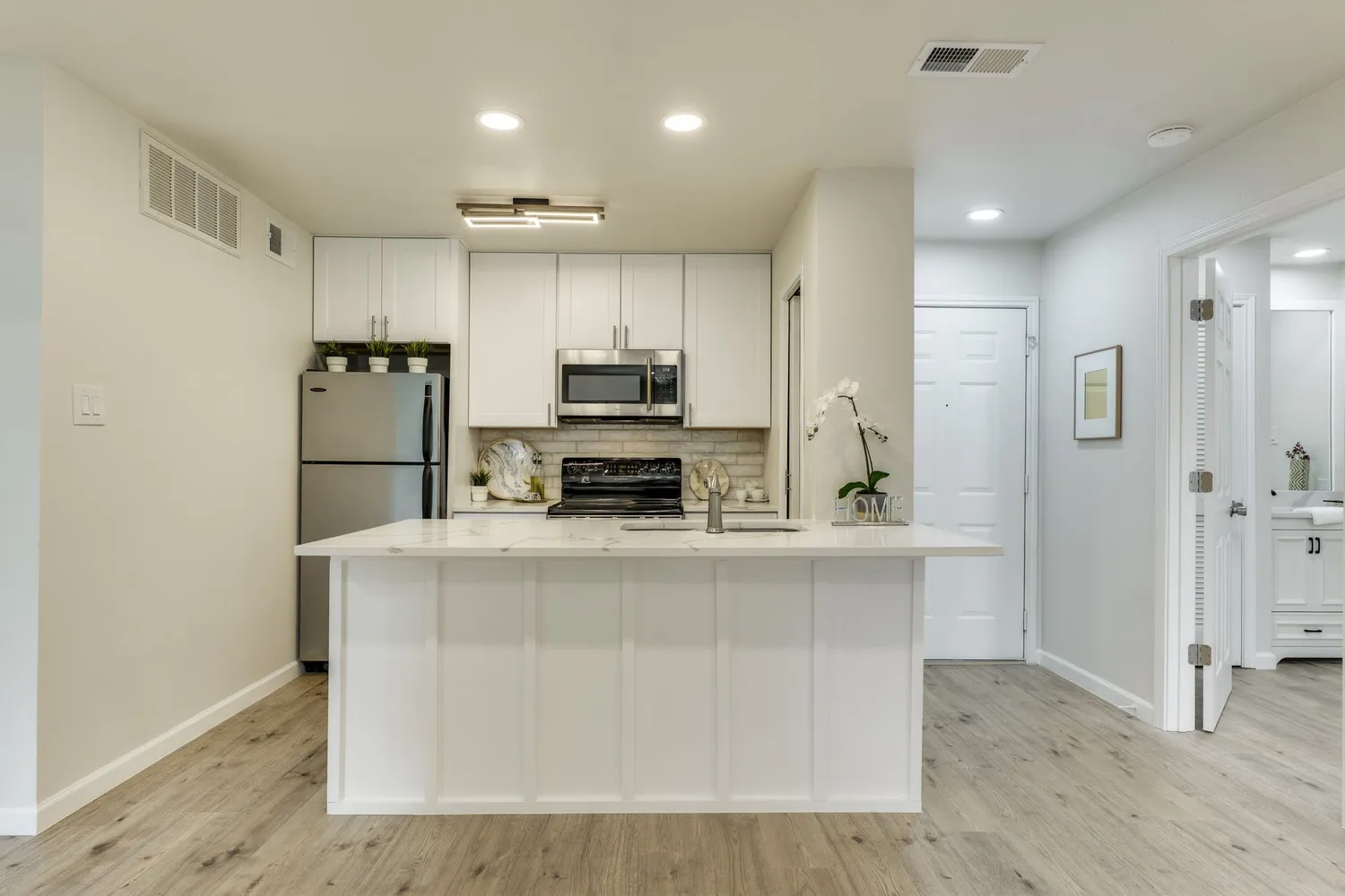 a kitchen with stainless steel appliances a stove a sink and a microwave