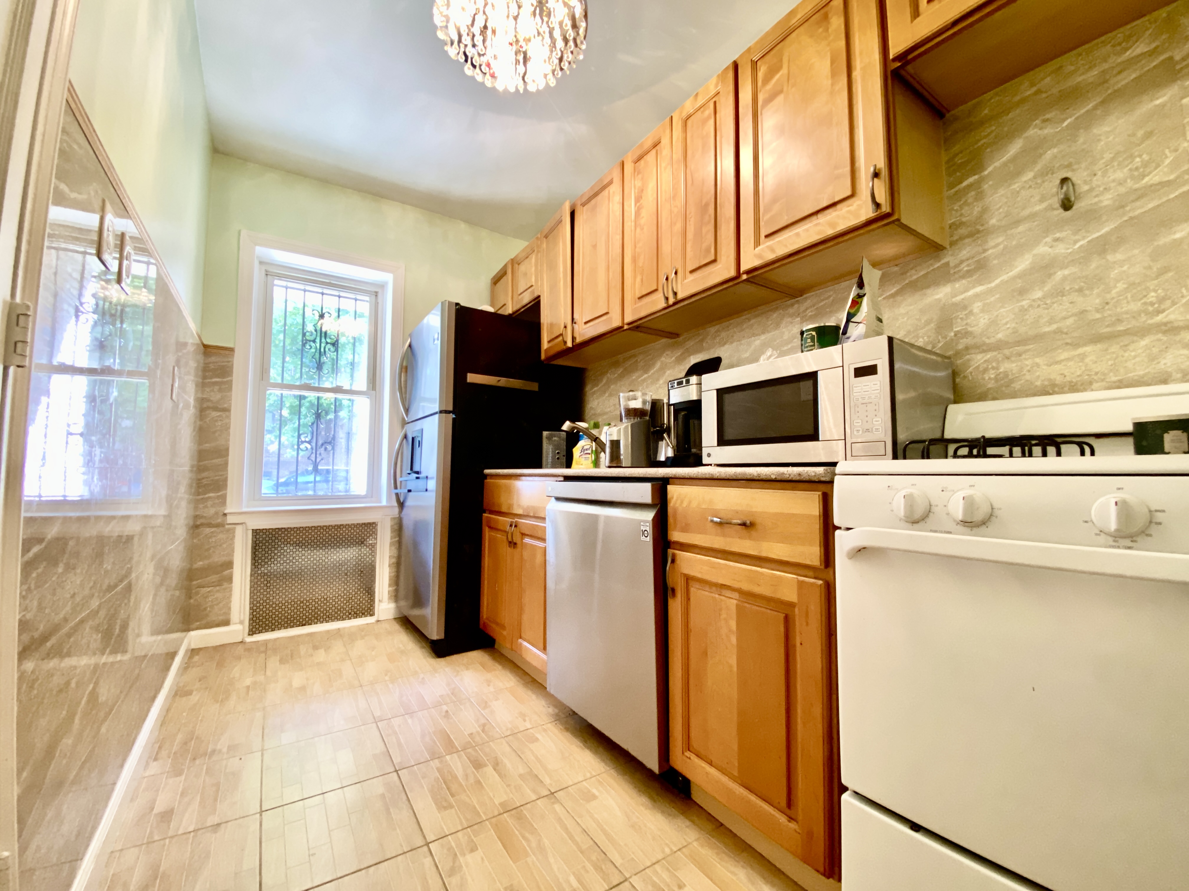 a kitchen with stainless steel appliances granite countertop a refrigerator a stove and a sink with cabinets