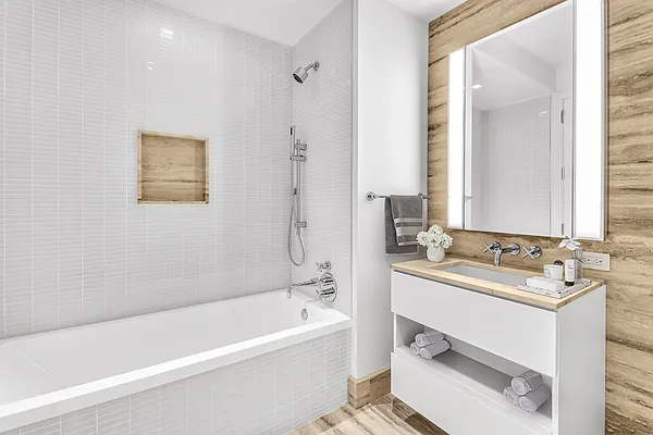 1 Wall Street, Unit 2512 Manhattan, NY 10005 - Photo 10 of 31 a bathroom with a tub sink and mirror