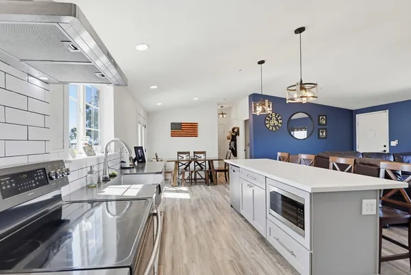 a view of a dining room and livingroom with furniture wooden floor a chandelier