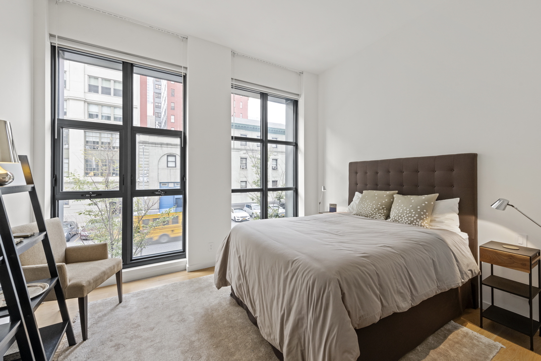 11 North Moore Street, Unit 2B Manhattan, NY 10013 - Photo 7 of 12 a bedroom with a large bed and a large window