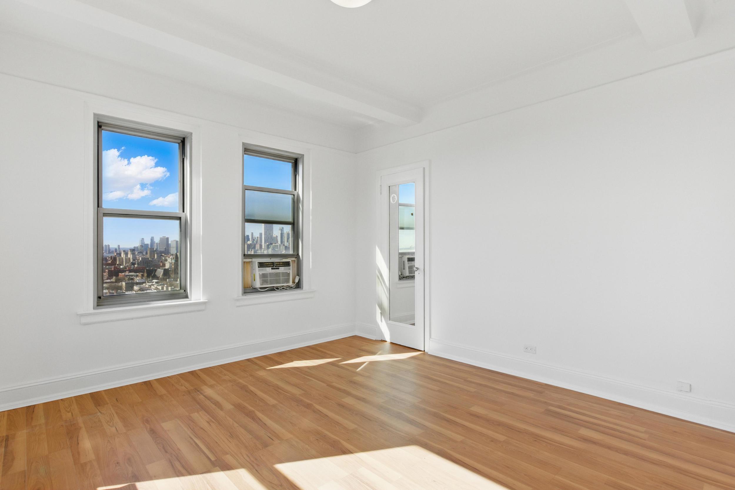 1 Plaza Street West, Unit 12C Brooklyn, NY 11217 - Photo 11 of 13 an empty room with wooden floor and windows