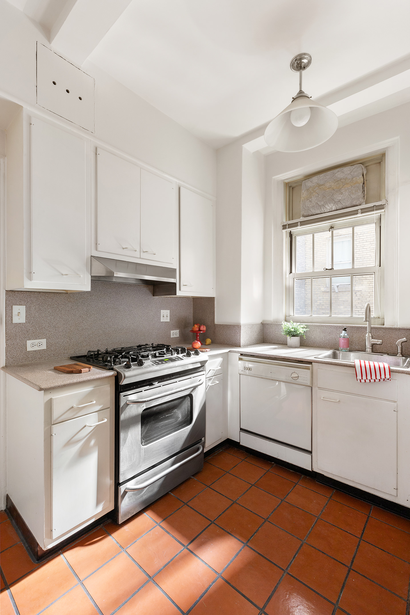 125 East 63rd Street, Unit 2B Manhattan, NY 10065 - Photo 8 of 12 a kitchen with granite countertop appliances sink and cabinets