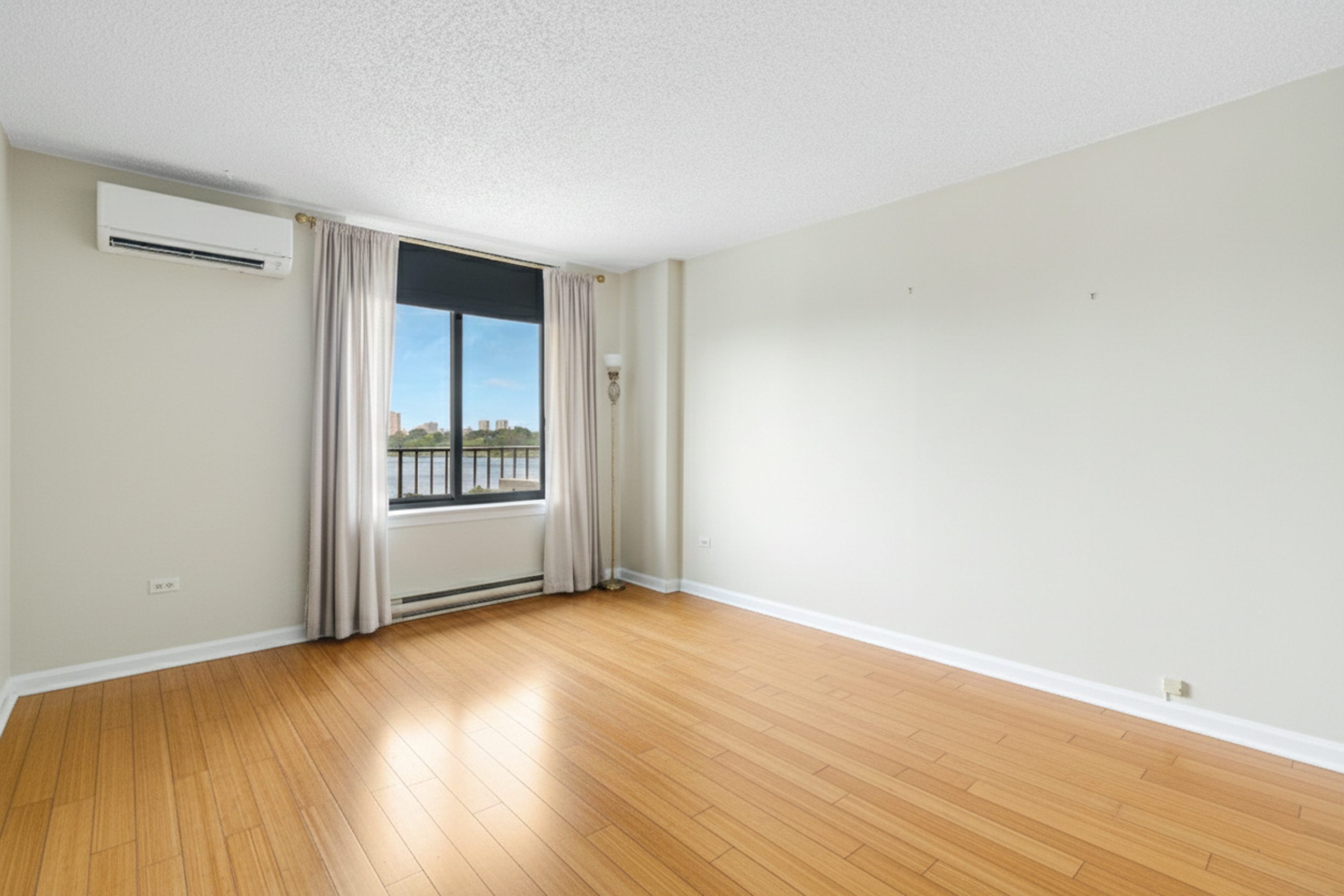 2540 Shore Boulevard, Unit 4S Queens, NY 11102 - Photo 13 of 31 a view of an empty room with wooden floor and a window