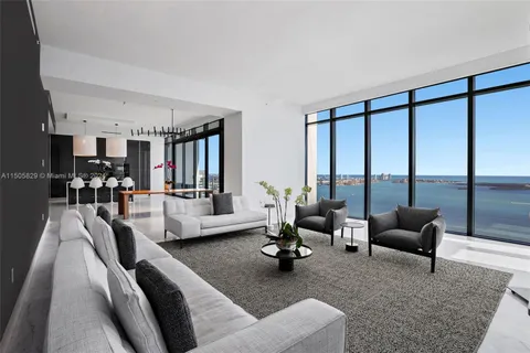a living room with furniture and floor to ceiling windows