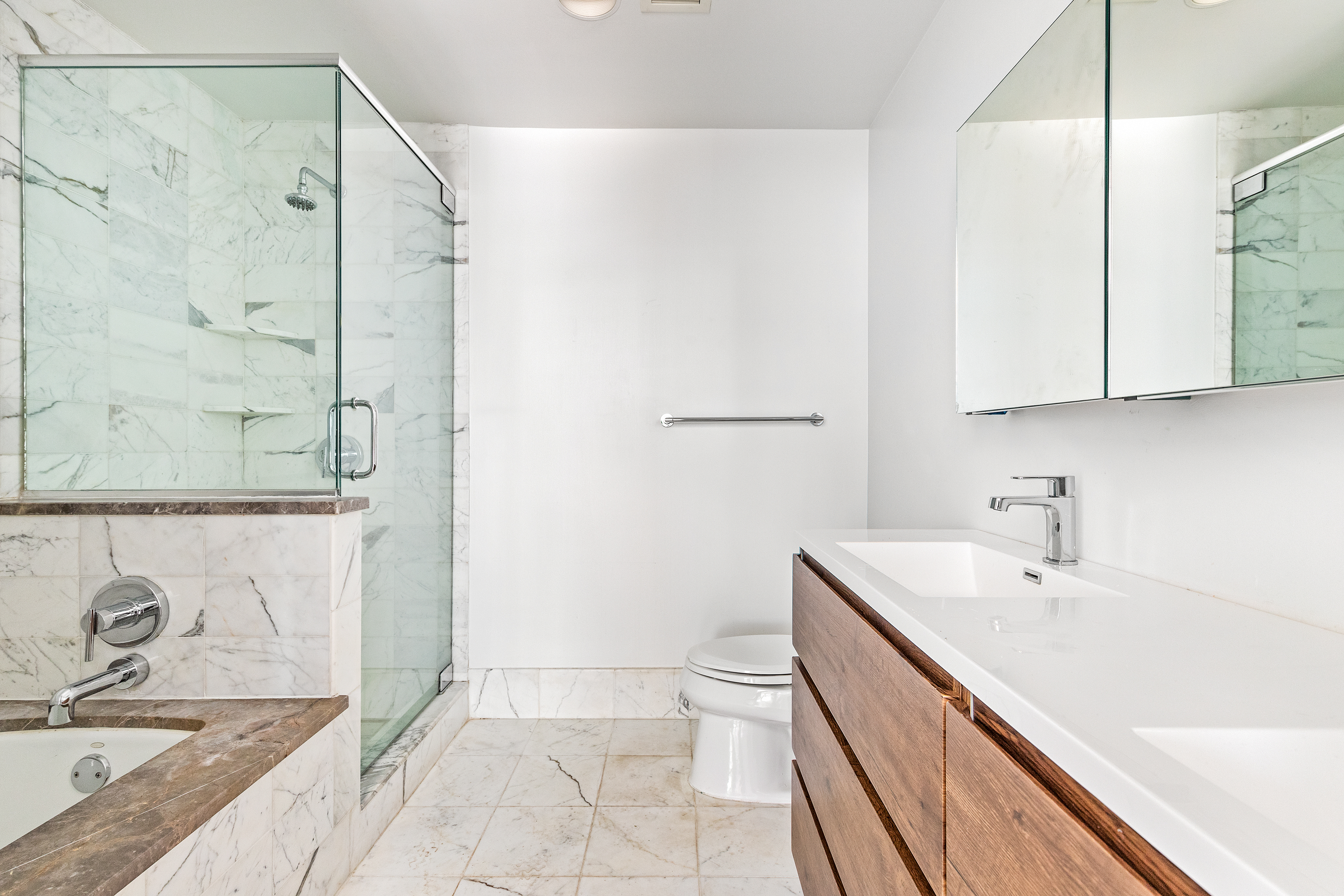 440 Kent Avenue, Unit 1B Brooklyn, NY 11249 - Photo 7 of 20 a bathroom with a granite countertop sink a toilet and shower