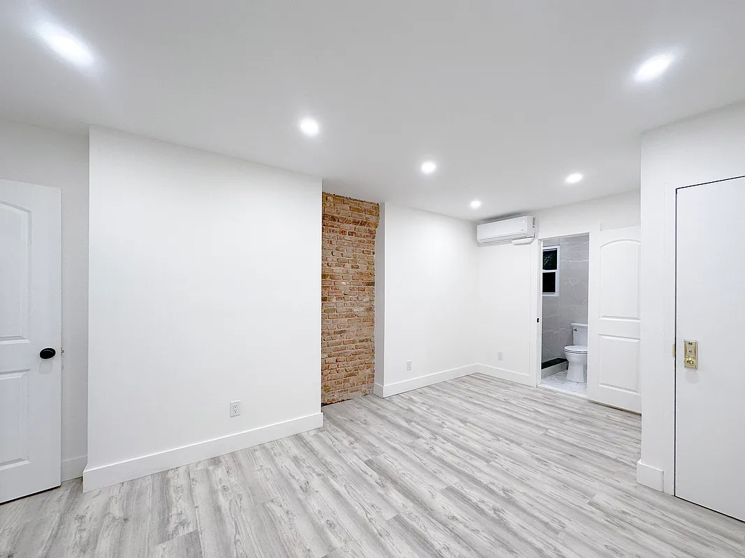 55 Spring Street, Unit 7 Manhattan, NY 10012 - Photo 7 of 12 wooden floor in an empty room with a window