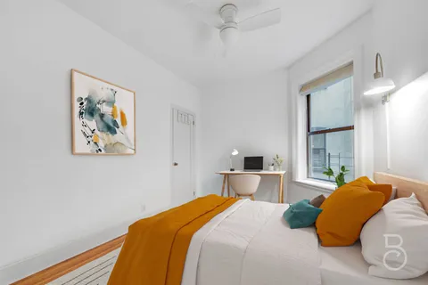 a bedroom with a large bed and a chandelier