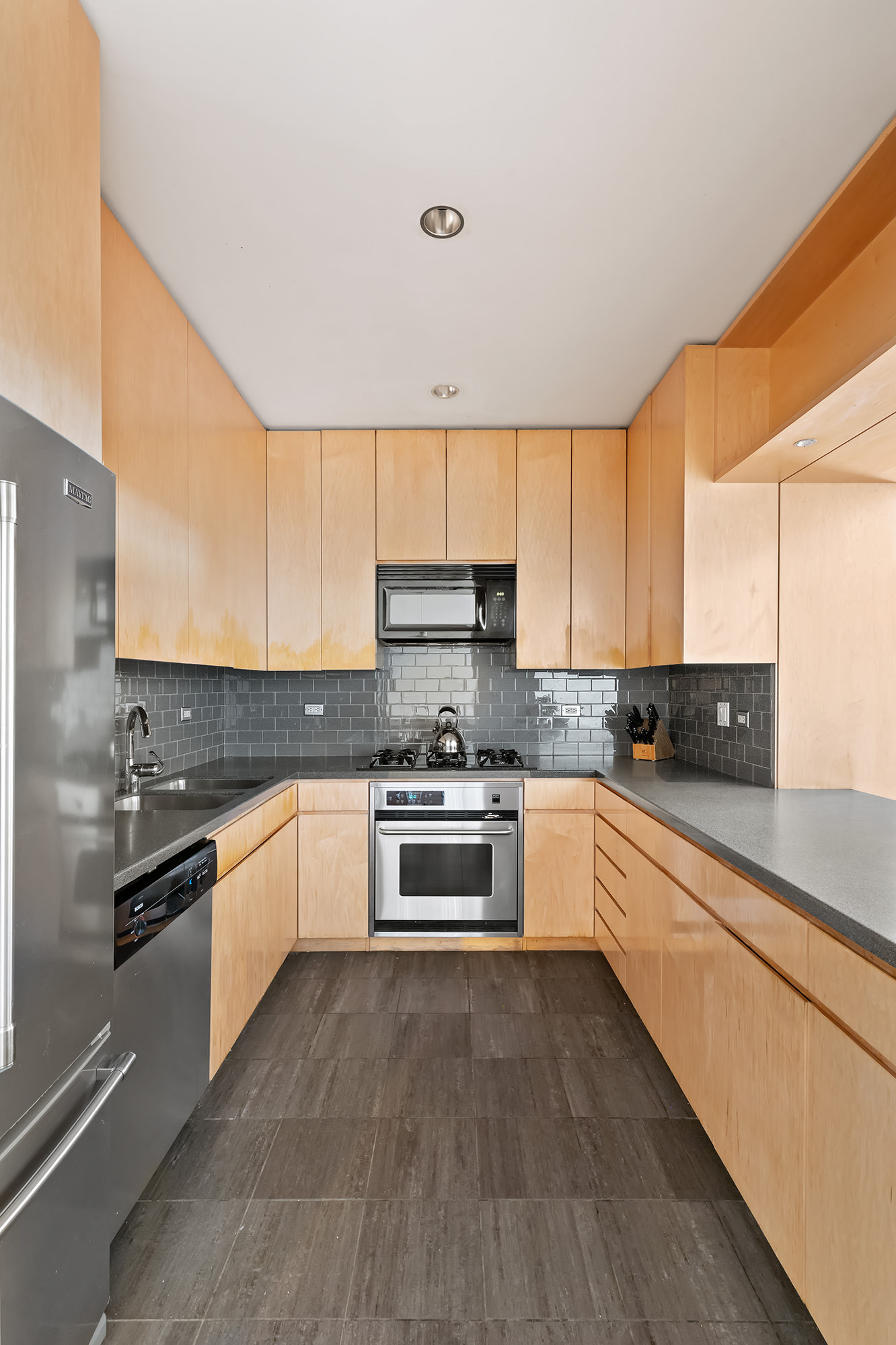 3 Hanover Square, Unit 14EF Manhattan, NY 10004 - Photo 4 of 14 a kitchen with stainless steel appliances granite countertop a stove and a sink