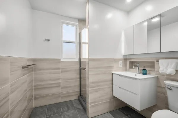 a bathroom with a sink a toilet and shower