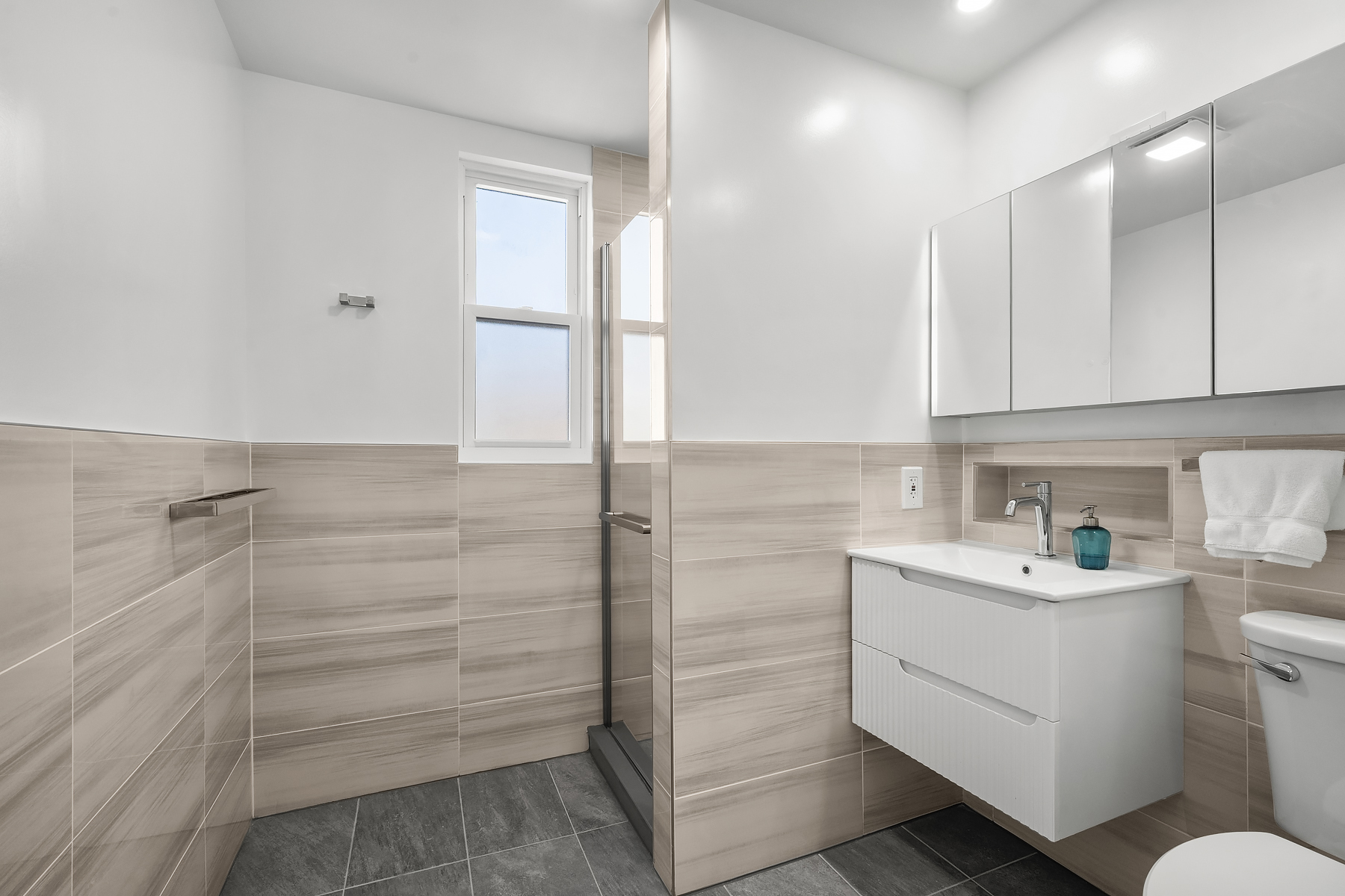 50-35 46th Street, Unit 2 Queens, NY 11377 - Photo 6 of 7 a bathroom with a sink a toilet and shower
