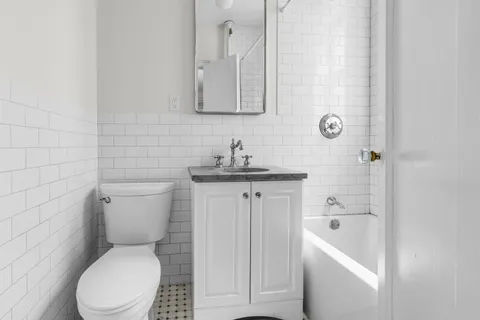 a white toilet sitting next to a bathroom sink