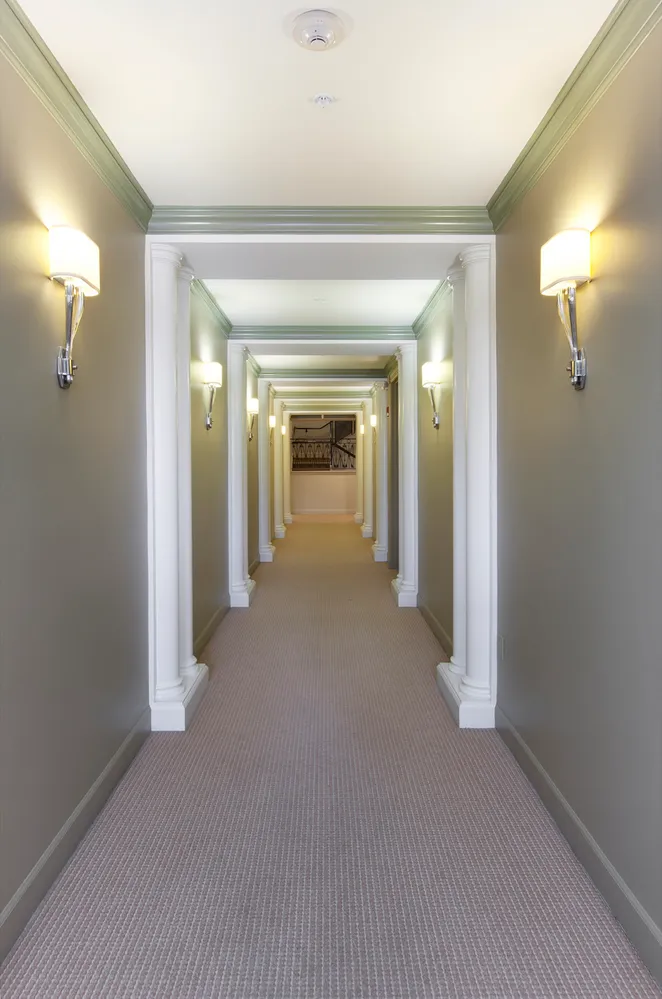 a view of a hallway with wooden floor and a mirror
