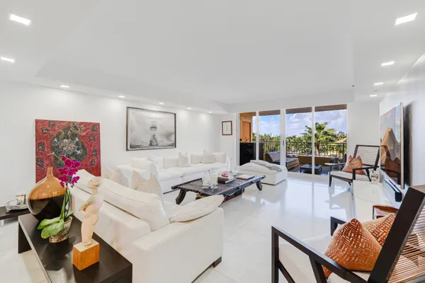 a living room with furniture flat screen tv and a large window