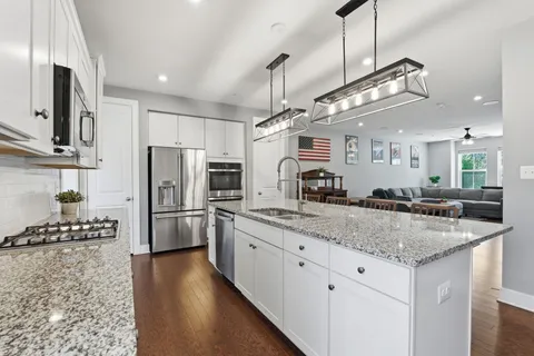 a kitchen with stainless steel appliances granite countertop a sink a stove and a refrigerator
